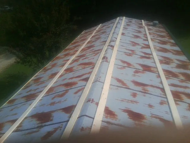 Rusted metal roof panels with new wood purlins before replacement — Storm Damage Roof Repair in Byesville by Roofing Brothers