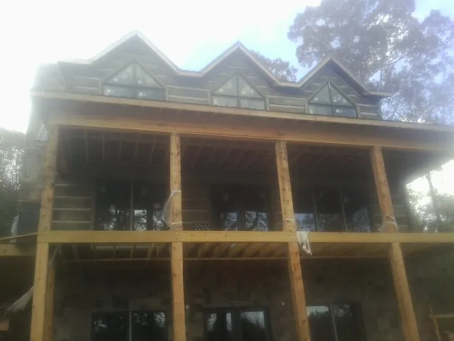 Dormers and porch framing on a large log home under construction — Roof Coating work by our crew in Byesville