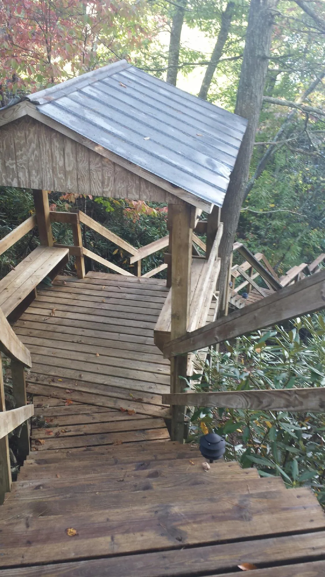 Metal roofed shelter over wooden steps on a wooded walkway — Skylight Repair & Installation work by our crew in Byesville